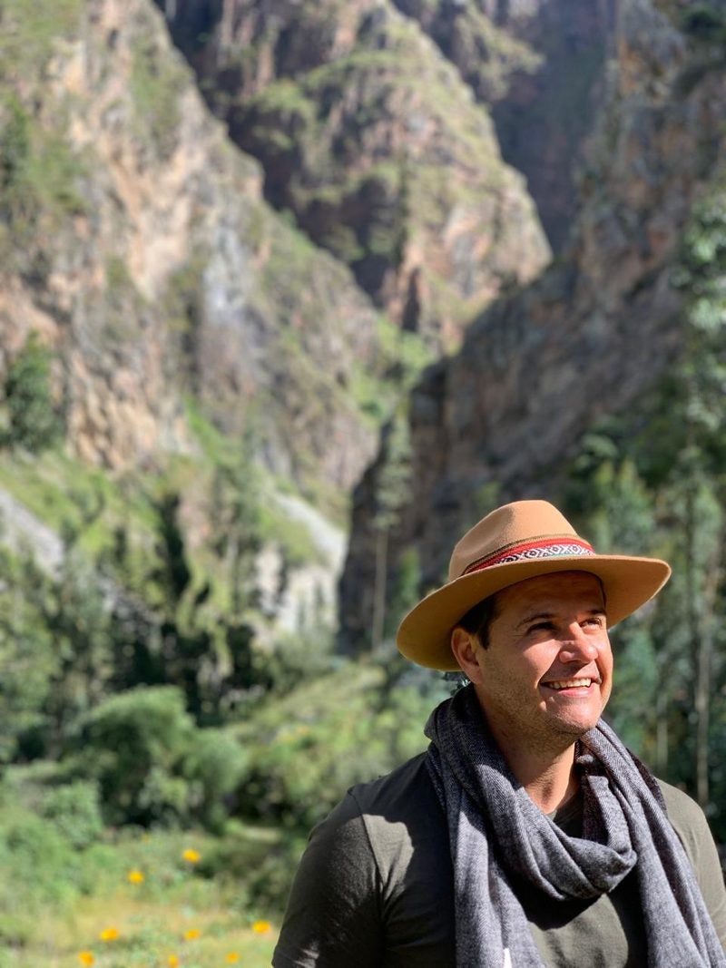 Retrato de Diego N Magalhães ao ar livre, em meio a montanhas